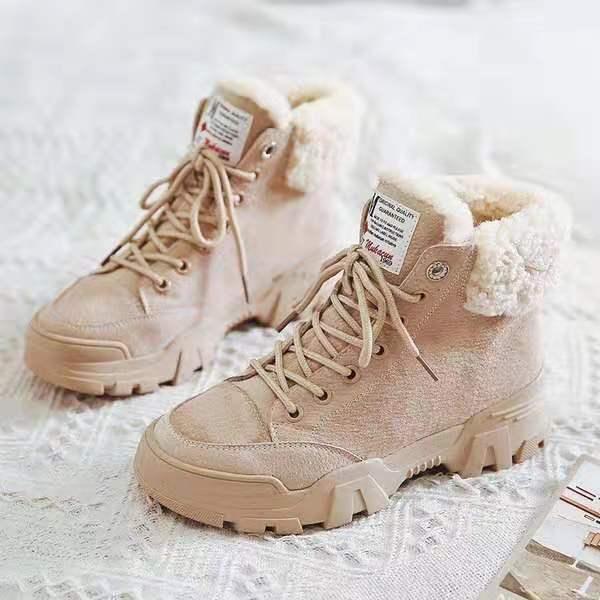 Beige winter boots with thick soles and fleece lining on a white textured surface