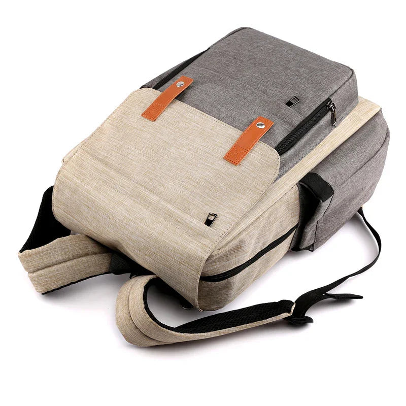 Modern two-tone grey and beige backpack with brown leather straps and black zipper accents