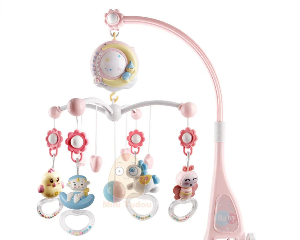 Pink baby crib mobile with hanging toys including a chick, baby figure, butterfly, and smiling bug