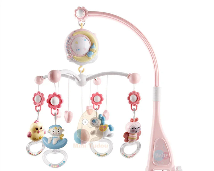 Pink baby crib mobile with hanging toys including a chick, baby figure, butterfly, and smiling bug