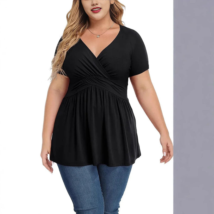 Plus size woman wearing black short sleeve wrap top with ruched waist and blue jeans