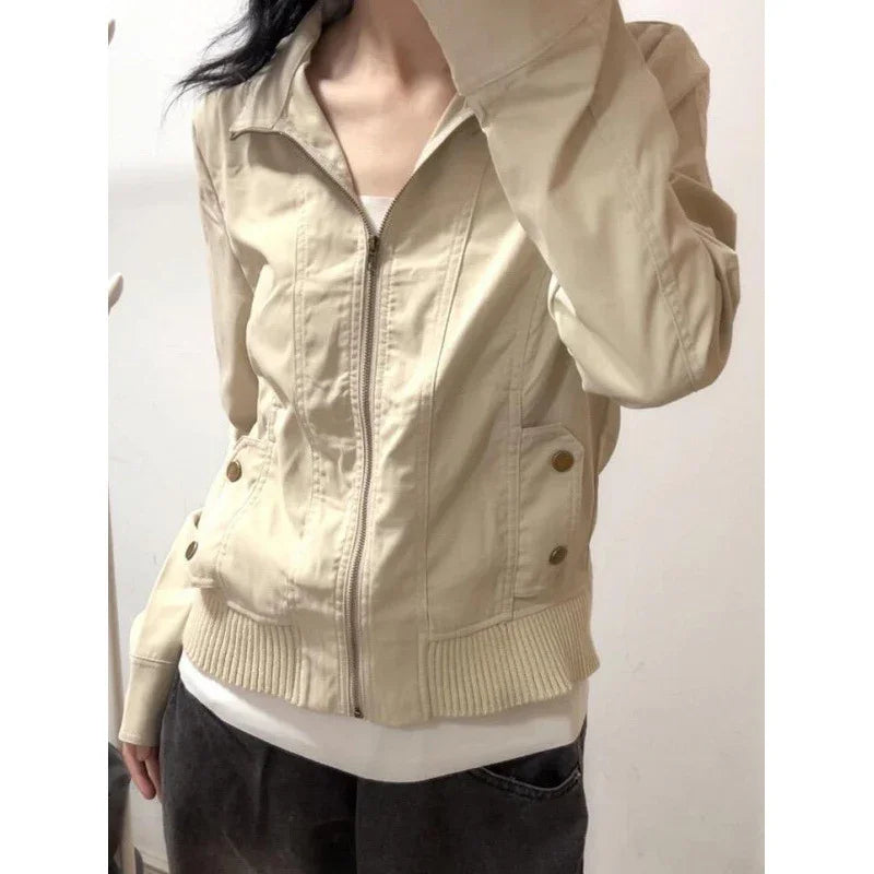 Woman wearing beige zip-up casual jacket with ribbed hem and buttoned pockets
