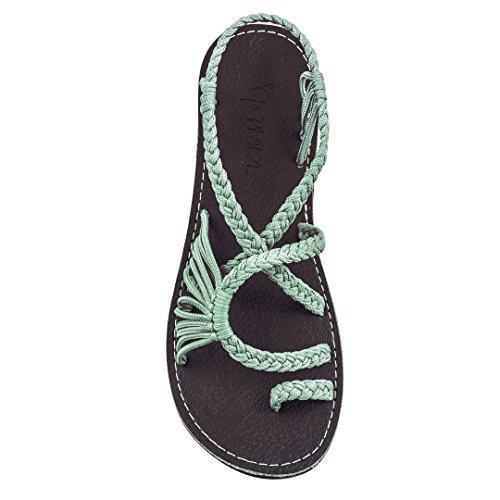 Top view of black sole sandal with light green braided straps on white background