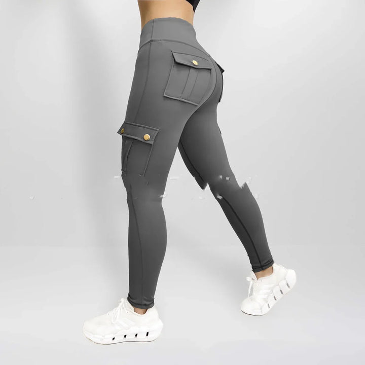 Woman wearing dark gray cargo pocket leggings and white athletic sneakers against light background