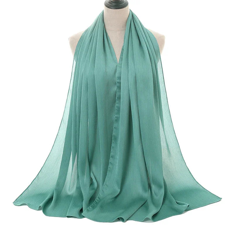 Light teal chiffon scarf draped on a mannequin against white background