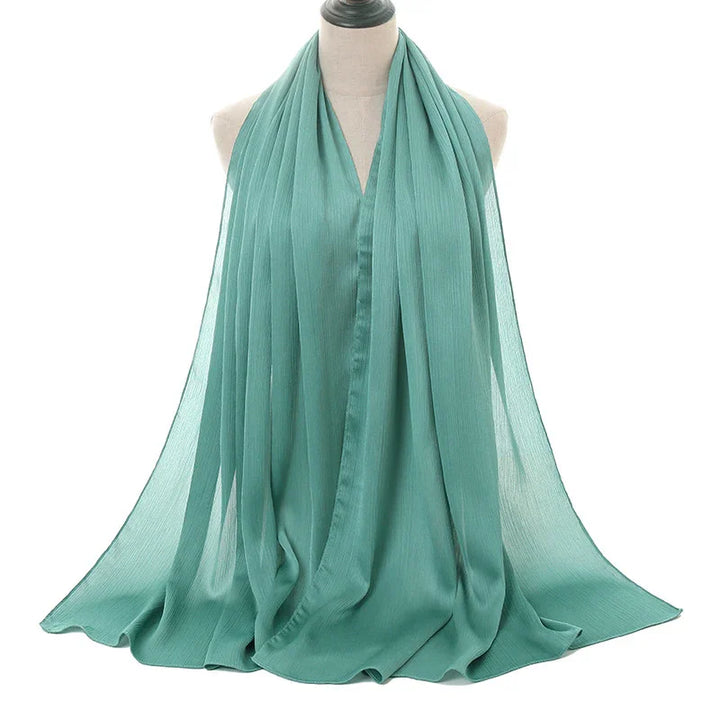 Light teal chiffon scarf draped on a mannequin against white background