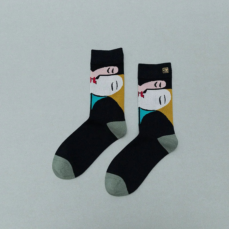 Black socks with abstract face art featuring pink, white, red, blue, and mustard colors and gray toe and heel