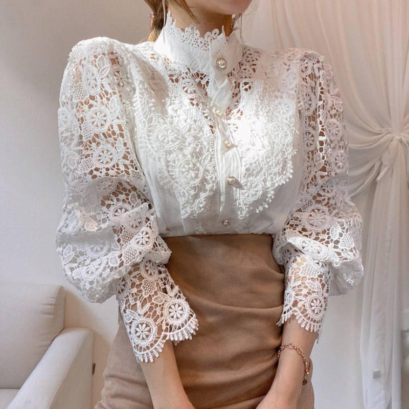Elegant woman wearing white floral lace blouse with pearl buttons and puff sleeves, paired with brown skirt