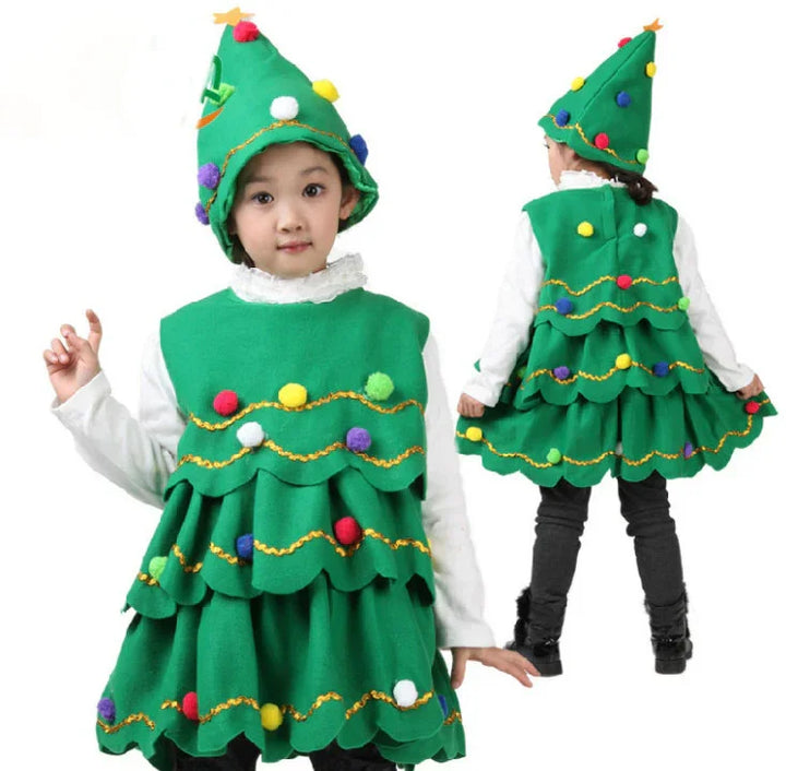 Child in green Christmas tree costume with colorful pom-poms and matching hat on white background
