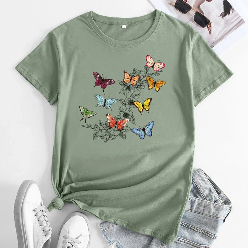 Light green t-shirt with colorful butterfly and floral print, styled with denim shorts and white sneakers