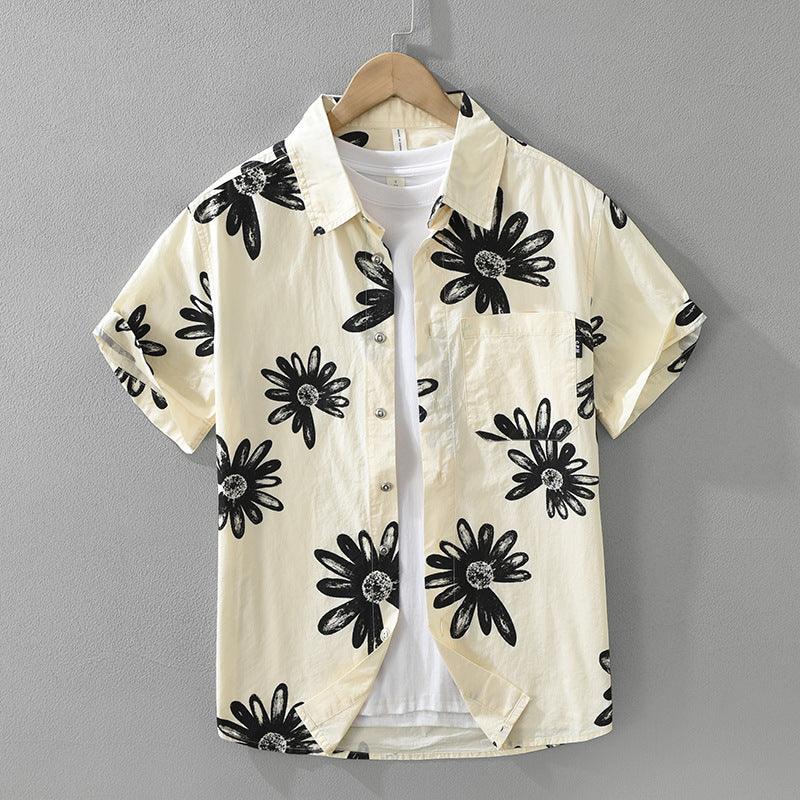 Short sleeve cream button-up shirt with black daisy floral print on wooden hanger