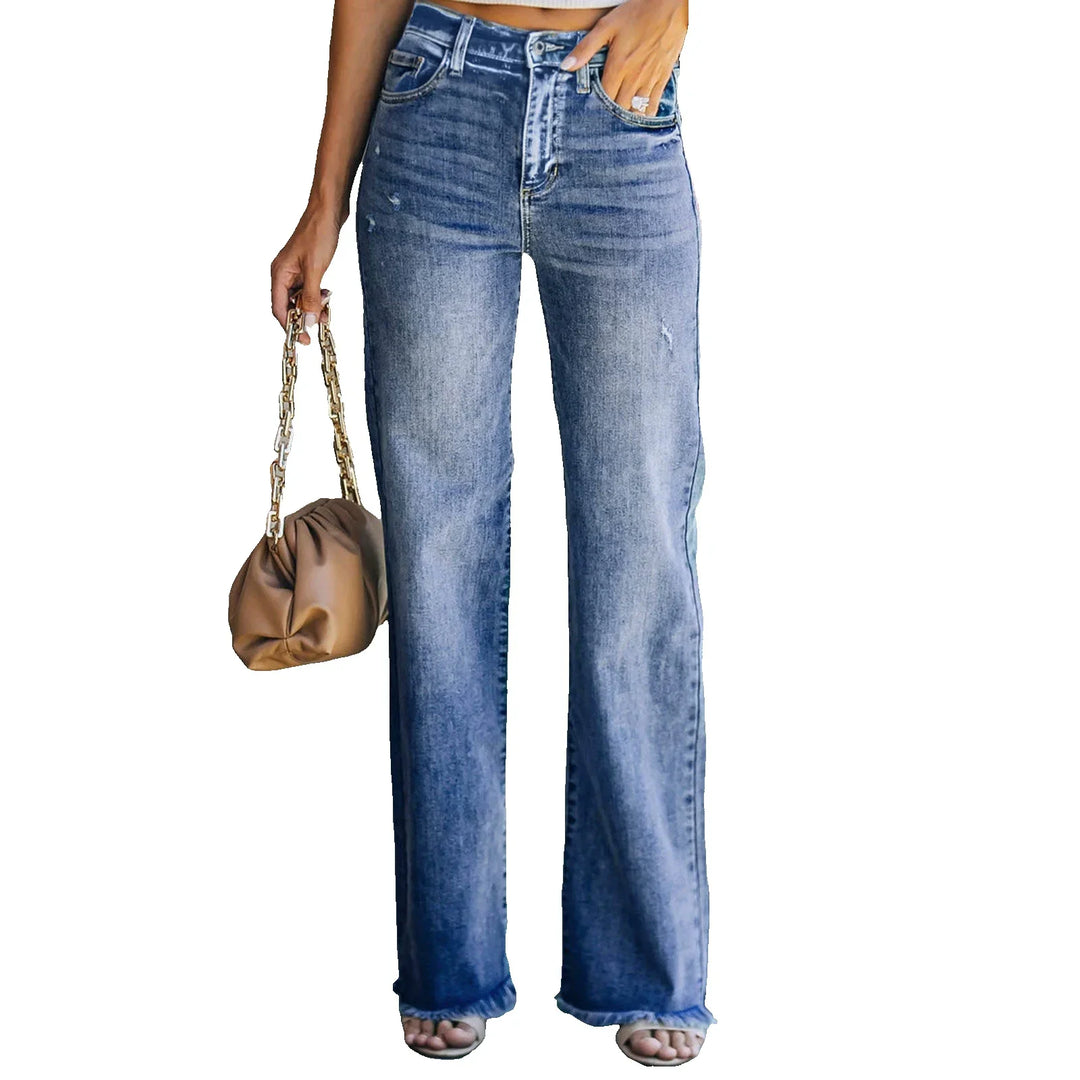 Woman wearing high-waisted wide-leg blue denim jeans holding brown handbag with chain strap