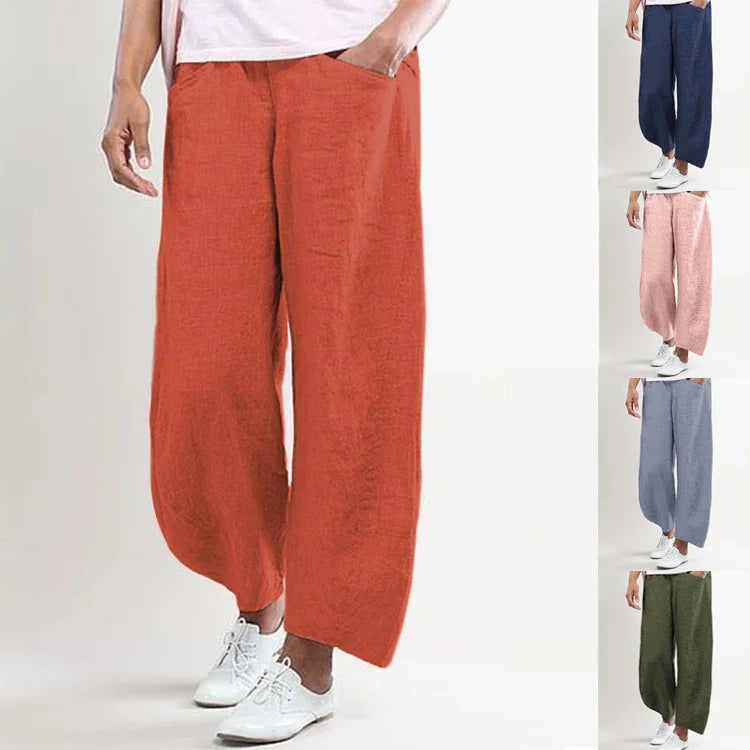 Loose fit casual wide-leg pants in terracotta red with side pockets, styled with white sneakers
