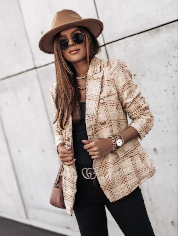 Stylish woman wearing brown hat, sunglasses, beige plaid blazer, black top, and black pants with Gucci belt