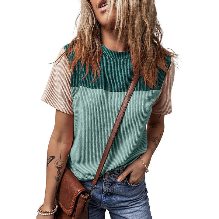 Casual color block ribbed knit top with green and beige sleeves worn with blue jeans and brown crossbody bag