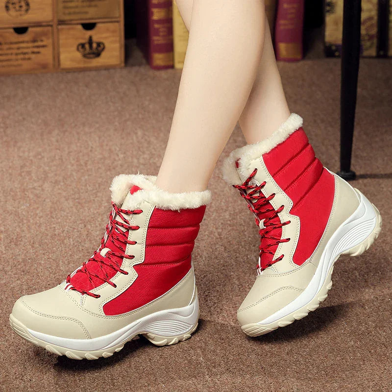 Red and beige winter boots with faux fur lining and lace-up design on carpeted floor