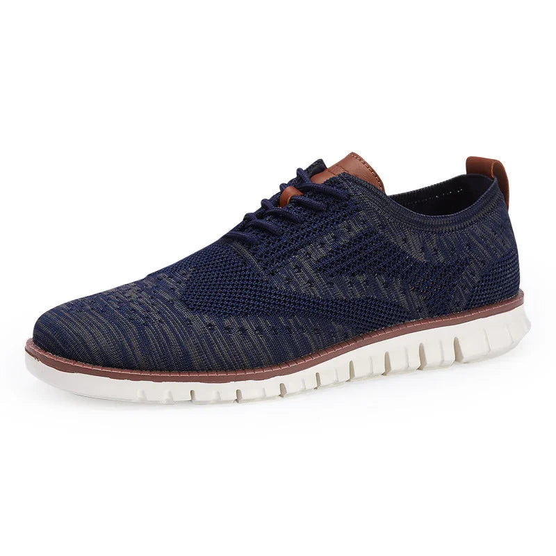 Navy blue knit casual sneaker with white sole and brown leather accents on tongue and heel