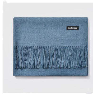 Folded blue cashmere scarf with fringed edges on white background