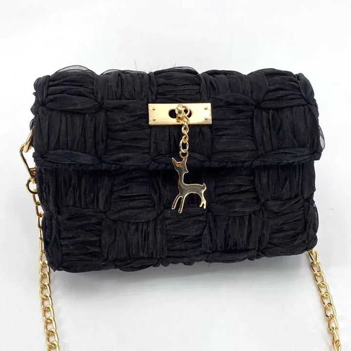 Black ruched fabric handbag with gold chain strap and deer charm on gold clasp
