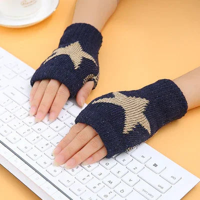 Hands wearing navy blue fingerless gloves with star pattern typing on white keyboard