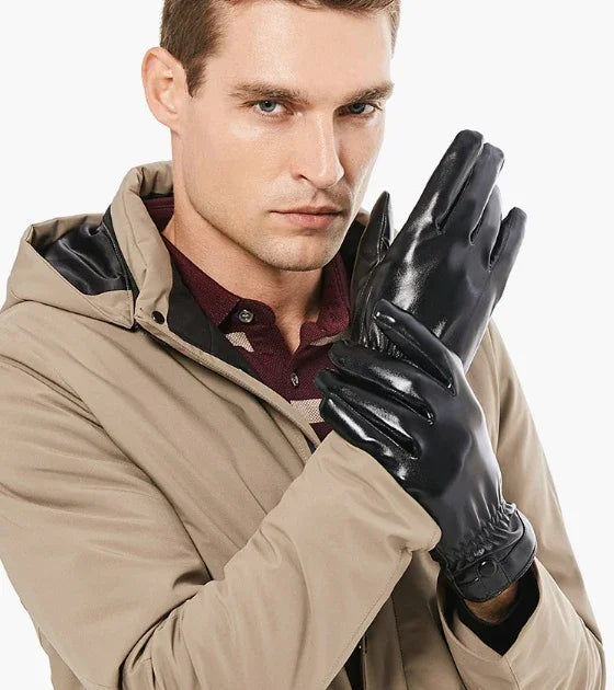 Man wearing beige jacket and black leather gloves in a studio setting