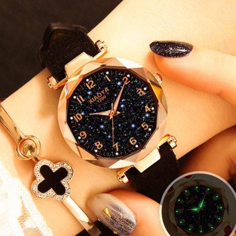 Women's elegant black starry sky watch with rose gold case and black leather strap on wrist