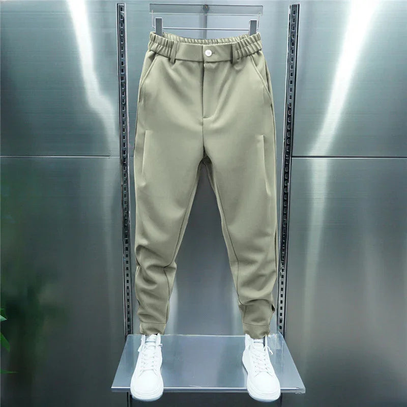 Beige casual jogger pants with elastic waistband and white sneakers displayed on mannequin