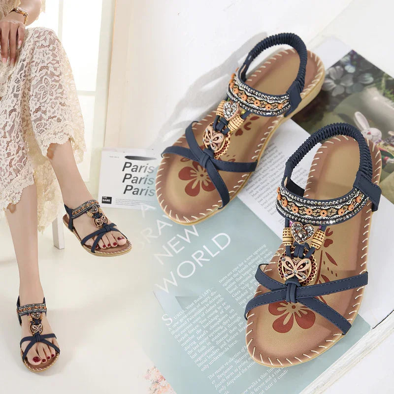 Elegant navy blue beaded women’s sandals with floral patterned footbed and elastic back strap