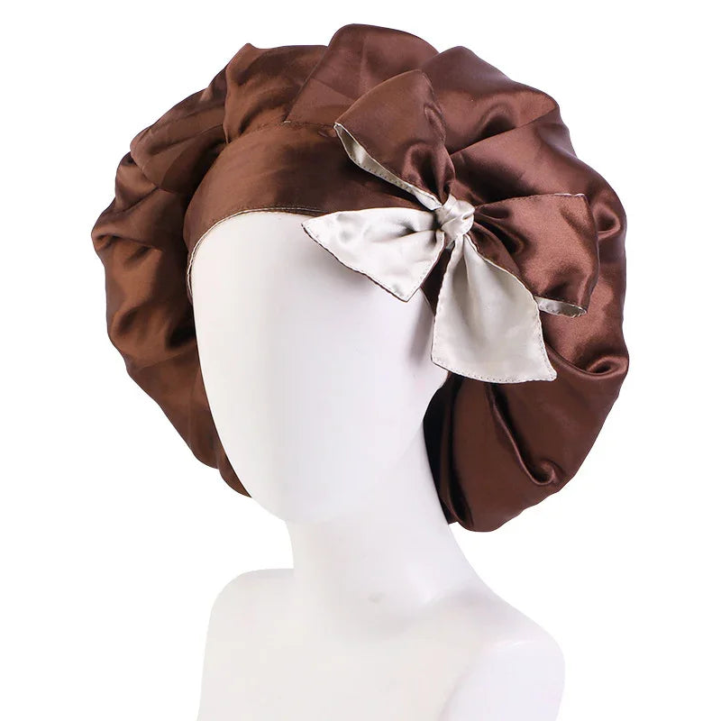 brown satin bonnet with white bow on white mannequin head against white background