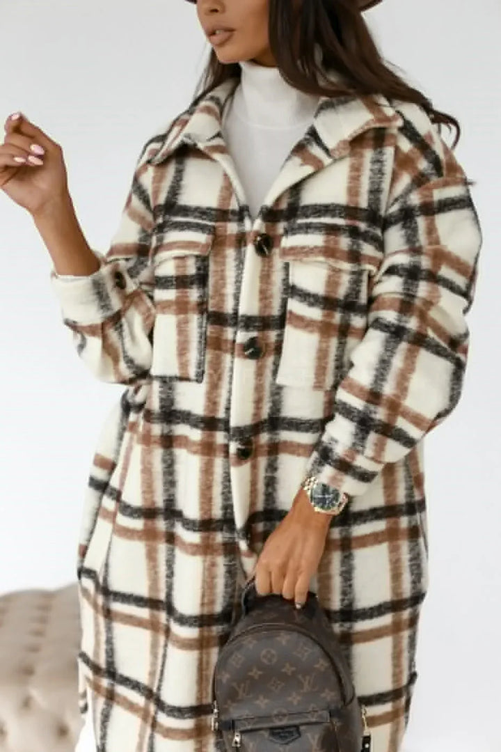 Woman wearing a white brown and black plaid wool coat holding a brown designer backpack