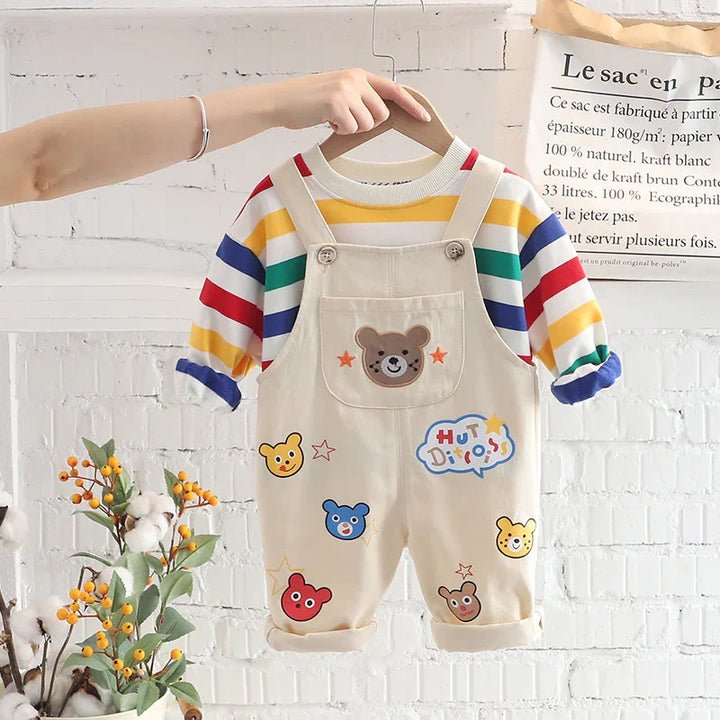 Children's cream overalls with colorful bear patches and striped long-sleeve shirt on hanger