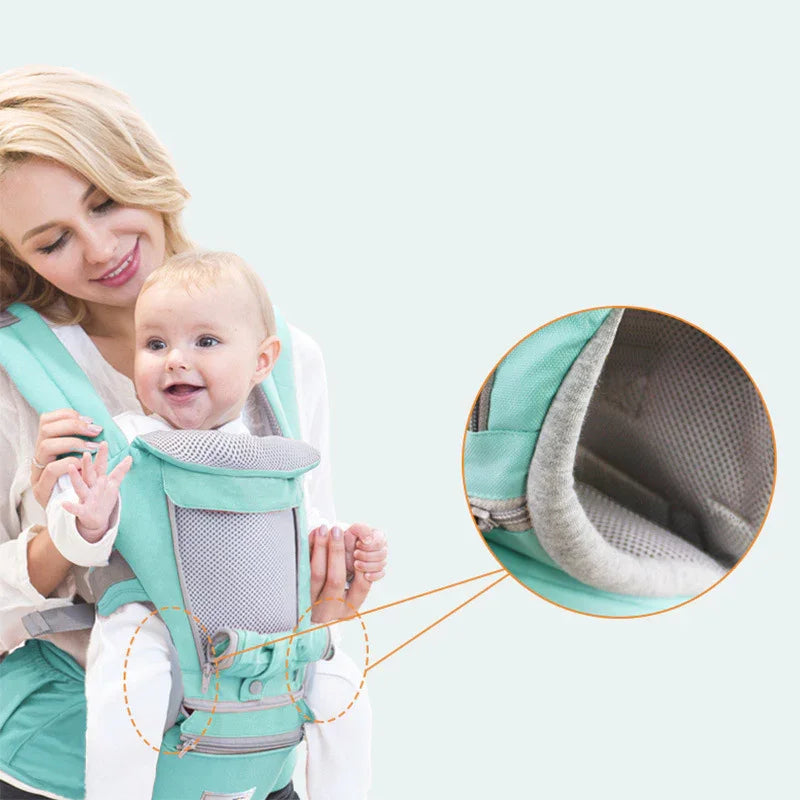 Mother carrying smiling baby in mint green ergonomic mesh baby carrier with padded straps