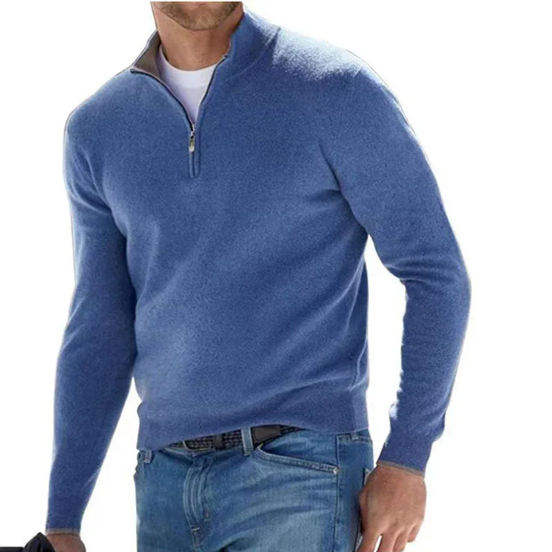 Man wearing blue quarter-zip sweater over white shirt with blue jeans