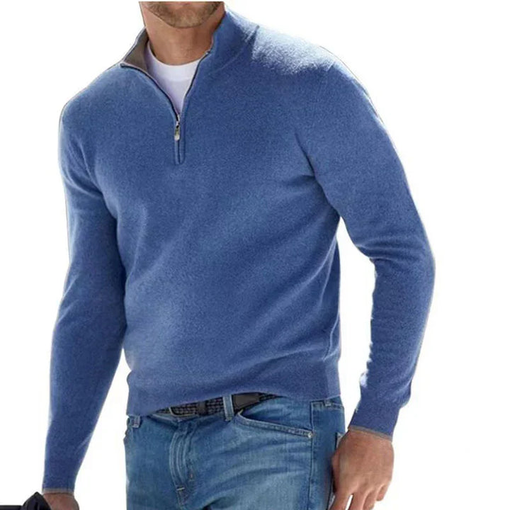 Man wearing blue quarter-zip sweater over white shirt with blue jeans