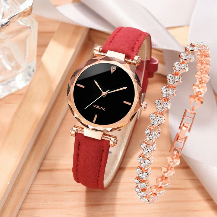 Elegant rose gold quartz watch with black dial and red strap next to a crystal-studded bracelet on wooden surface