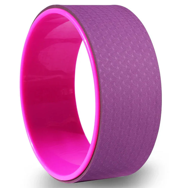Purple and pink yoga wheel for stretching and back support on white background