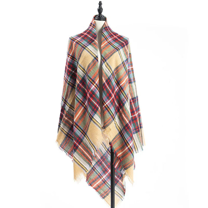 Plaid wool blanket scarf in red, green, blue, beige tones displayed on a mannequin