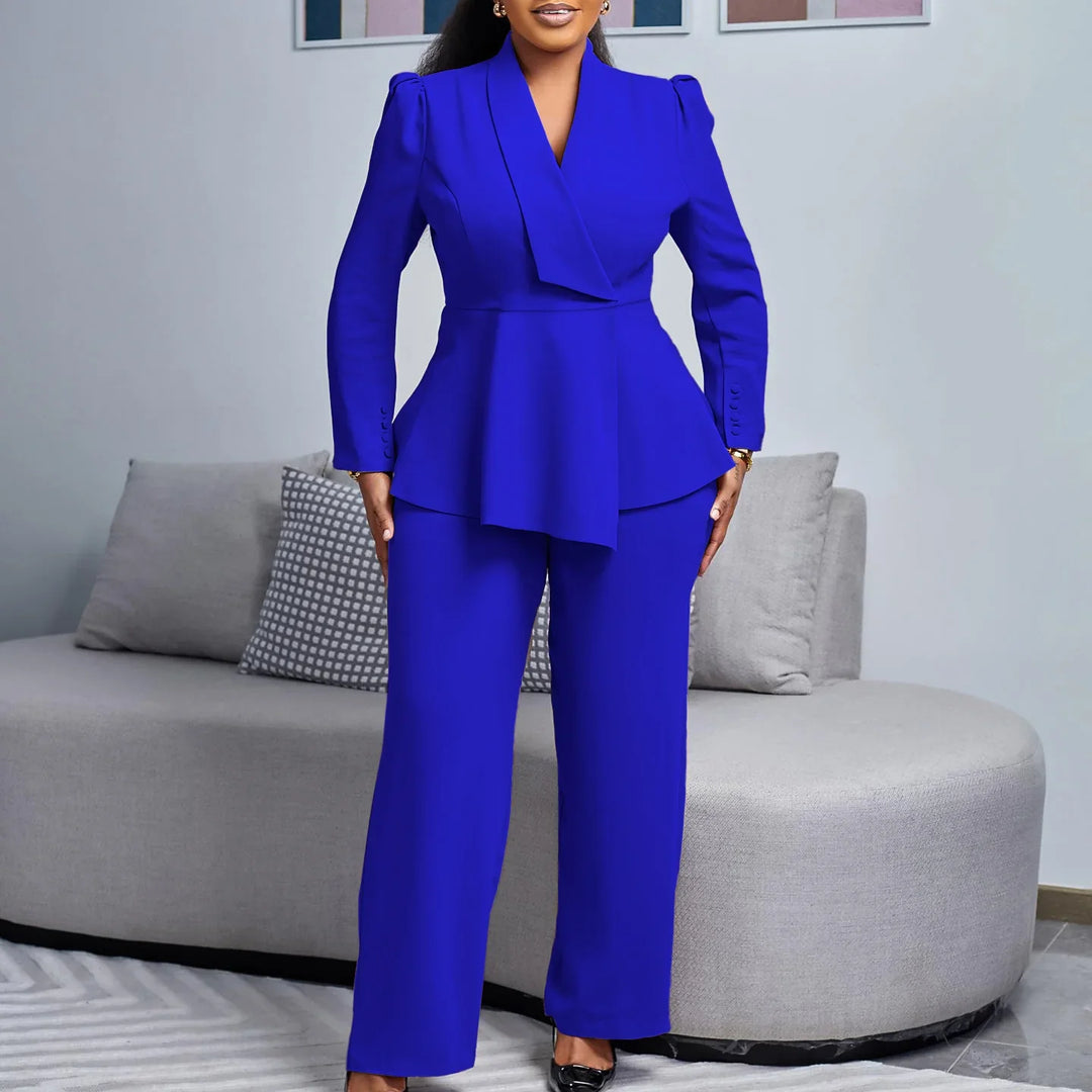 Woman in cobalt blue tailored peplum blazer and matching wide-leg pants in modern living room