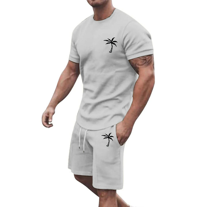 Man wearing light gray casual sweatshorts and t-shirt set with black palm tree print