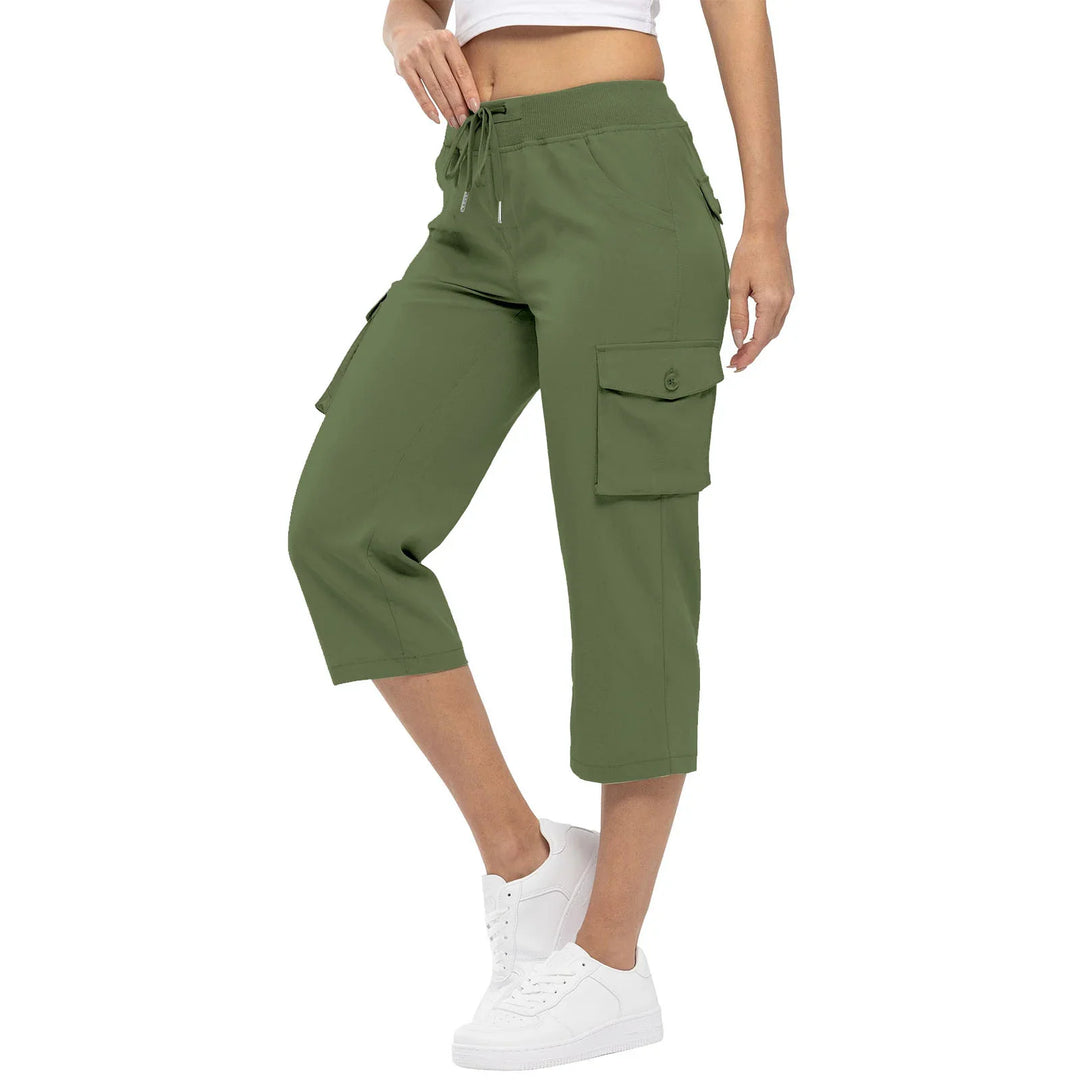 Woman wearing olive green cargo capri pants with button pockets and white sneakers