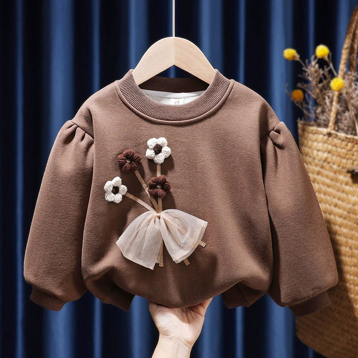 Brown toddler sweatshirt with puff sleeves and flower appliqué with a sheer bow on front