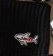 Black fabric with a white and red shark patch embroidered on it