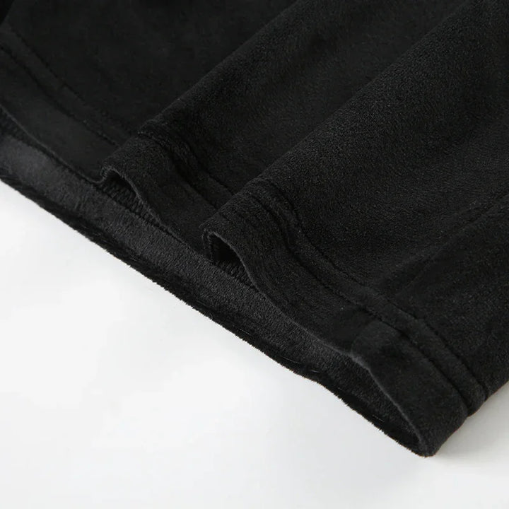 Close-up of black fleece fabric with detailed stitching on garment edge