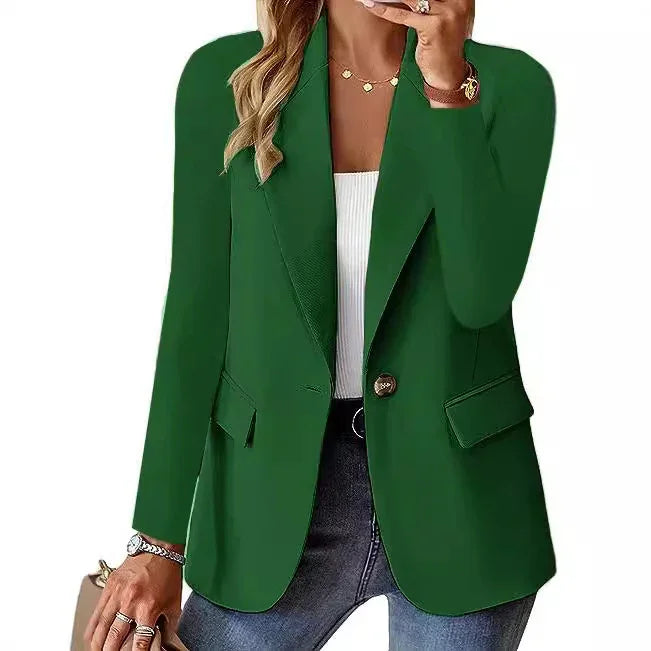 Woman wearing stylish dark green blazer with gold button and flap pockets over white top and jeans