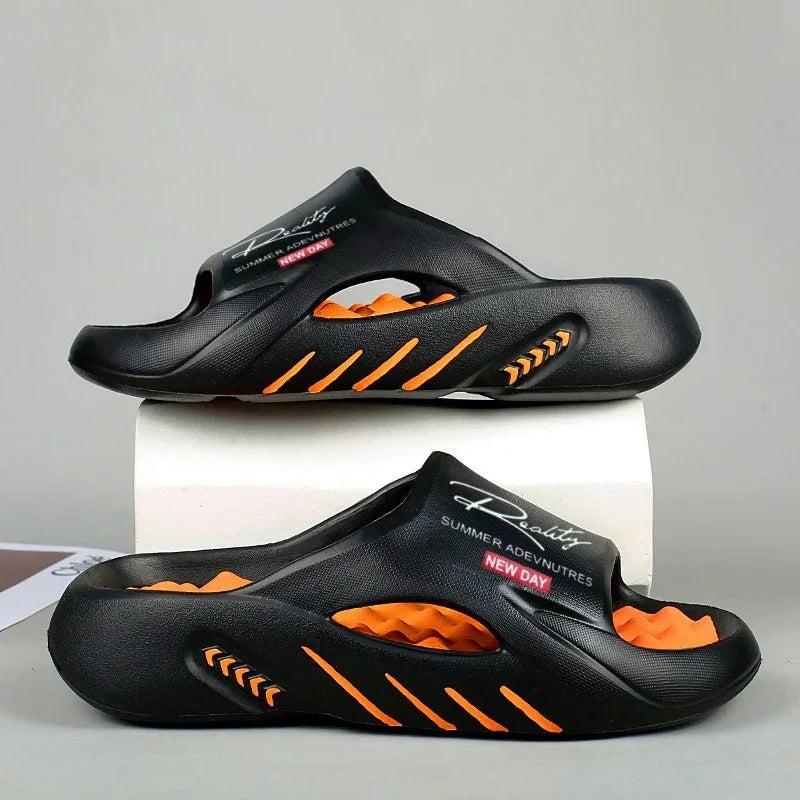 Black slip-on sandals with orange textured footbed and cutout design, branded with Reality Summer Adventures New Day