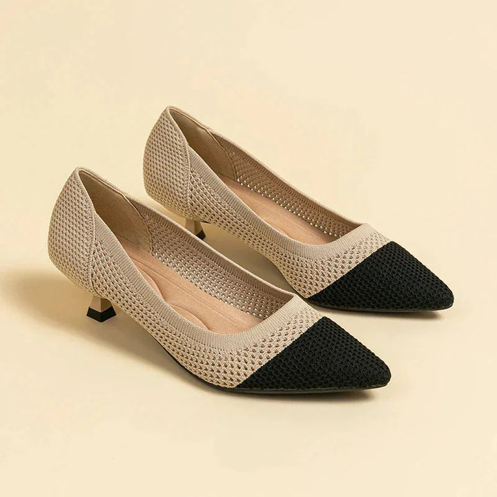 Beige knitted low heel women's shoes with black pointed toe on neutral background