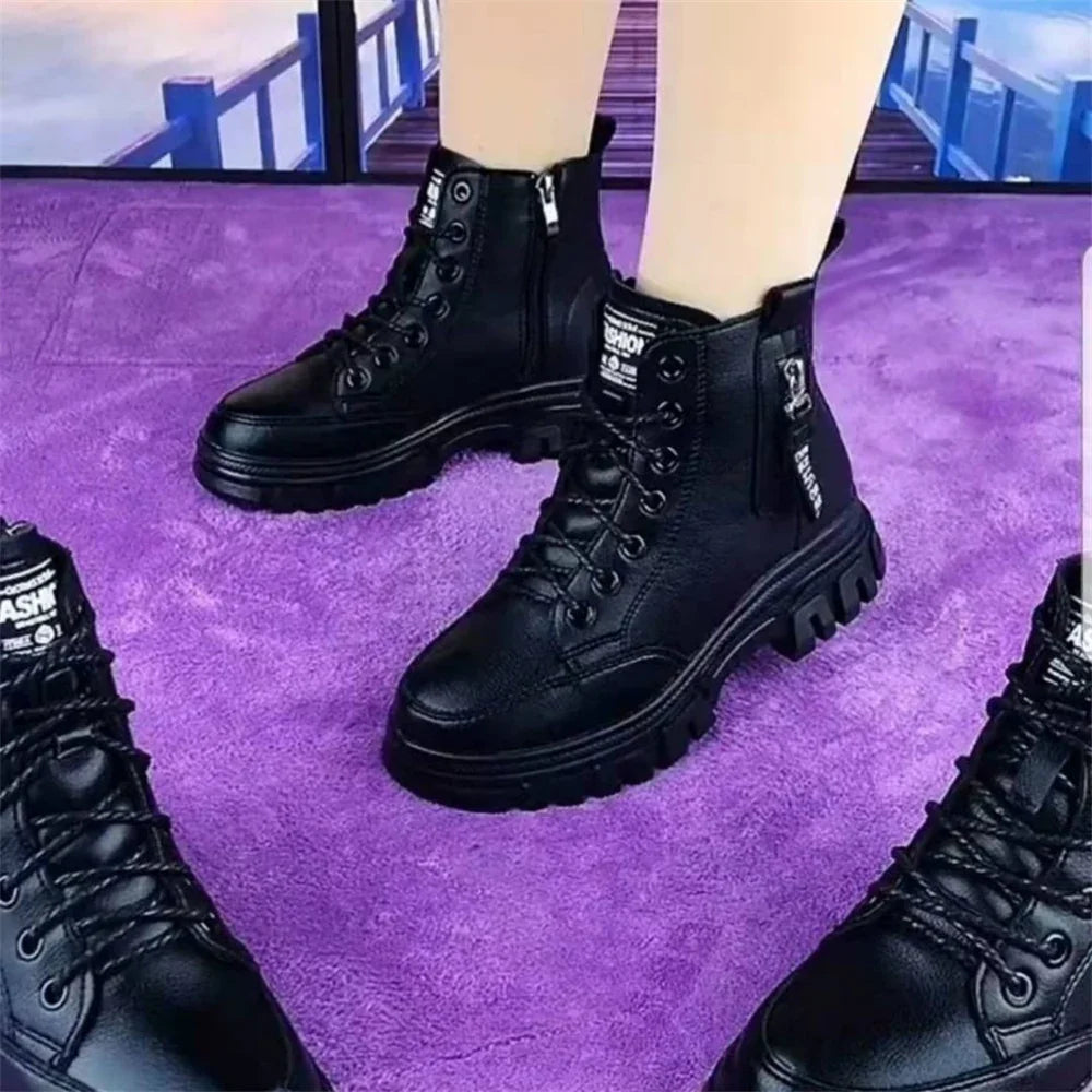 Black lace-up combat boots with zipper and thick sole worn on light skin, standing on purple carpet
