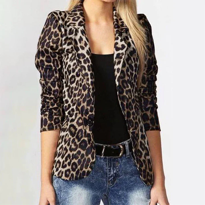 Woman wearing leopard print blazer with ruched sleeves, black top, and blue jeans