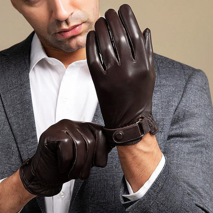 Man wearing dark brown leather gloves with button strap, dressed in white shirt and gray blazer