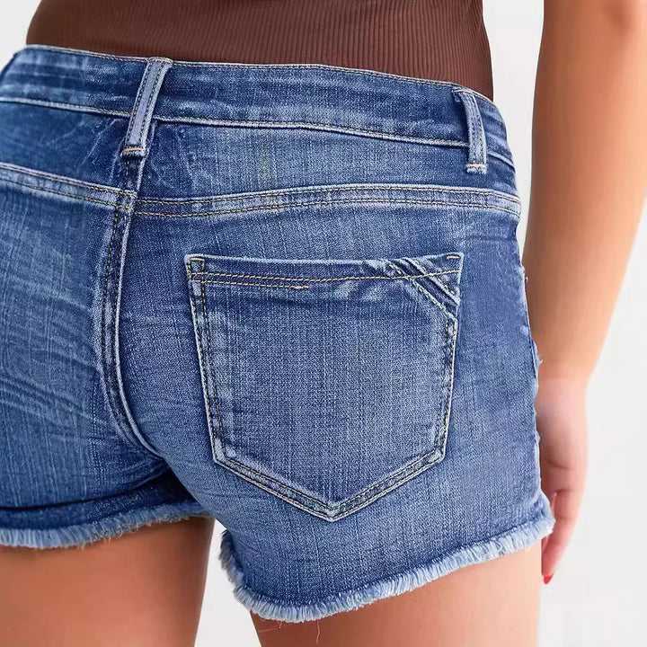 Close-up of woman wearing blue denim shorts with frayed hem and a brown top